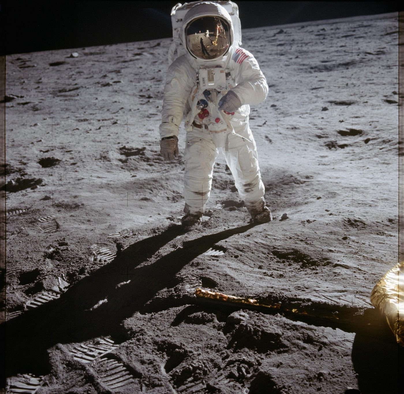 Buzz Aldrin caminha na superfície lunar ao lado de uma das pernas do módulo lunar Eagle, em fotografia feita por Neil Armstrong.