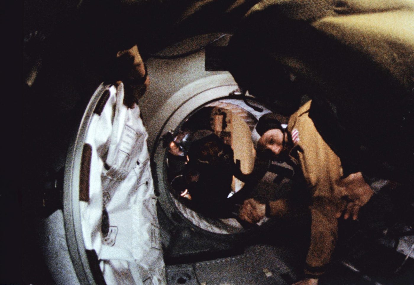 Thomas Stafford e Aleksei Leonov trocam o aperto de mão no túnel que liga as naves Apollo e Soyuz, em quadro de filme de 16 mm.